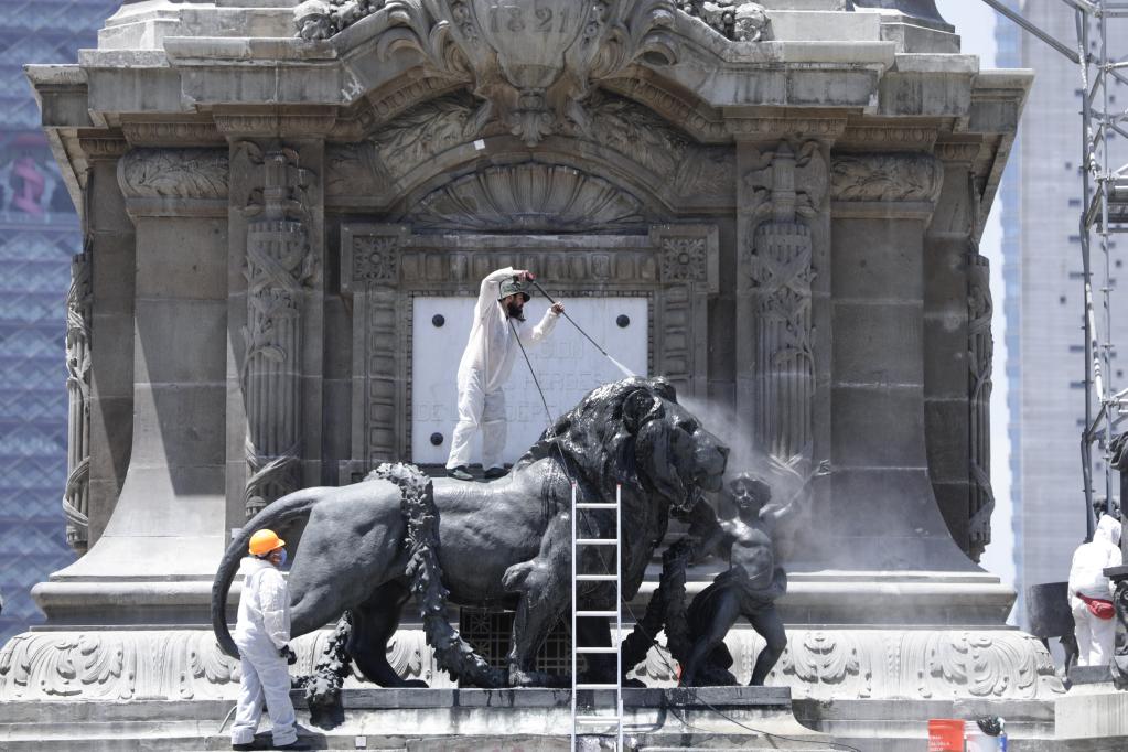 Trabajadores realizan labores de restauración en una escultura del Monumento a la Independencia