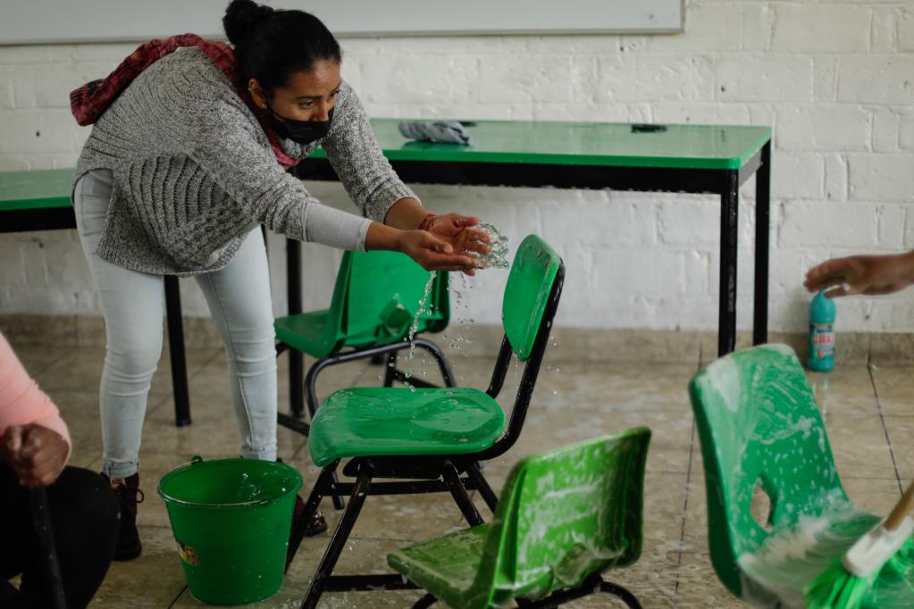 Mujeres realizan limpieza en escuelas previo al regreso a clases en México