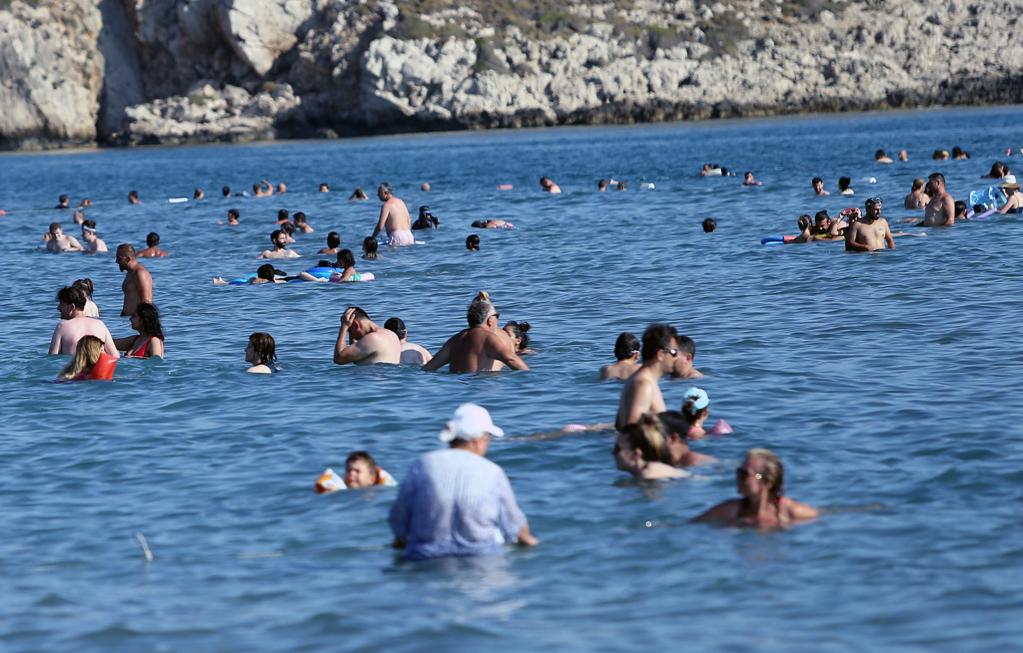 Personas disfrutan su tiempo libre frente al mar Mediterráneo en Antalya, Turquía