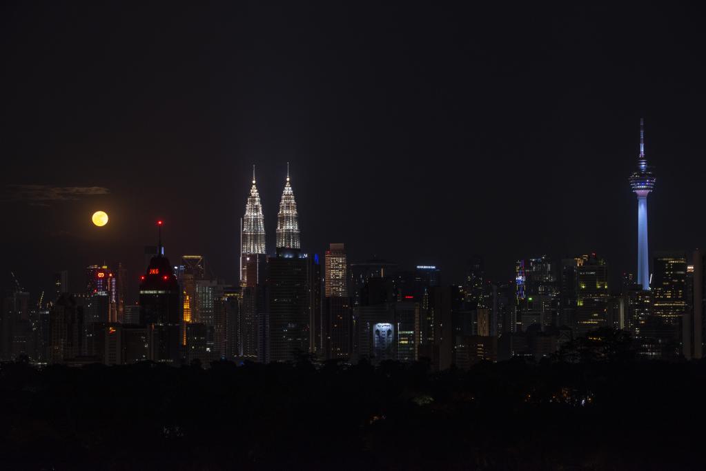 Luna llena en horizonte en Kuala Lumpur, Malasia
