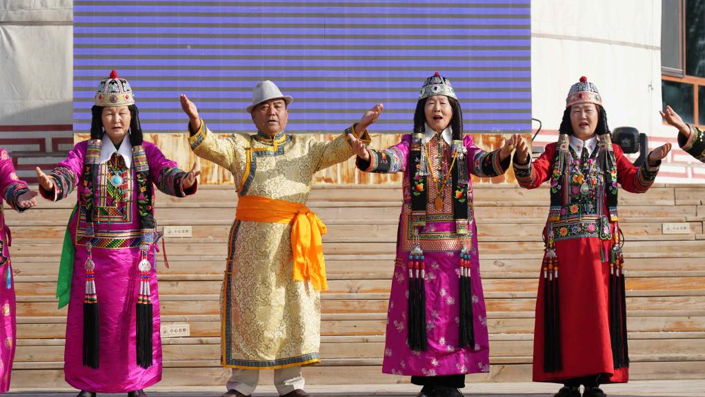 Herederos del patrimonio cultural intangible y artistas folclóricos realizan presentaciones en un área escénica del lago Bosten, Xinjiang