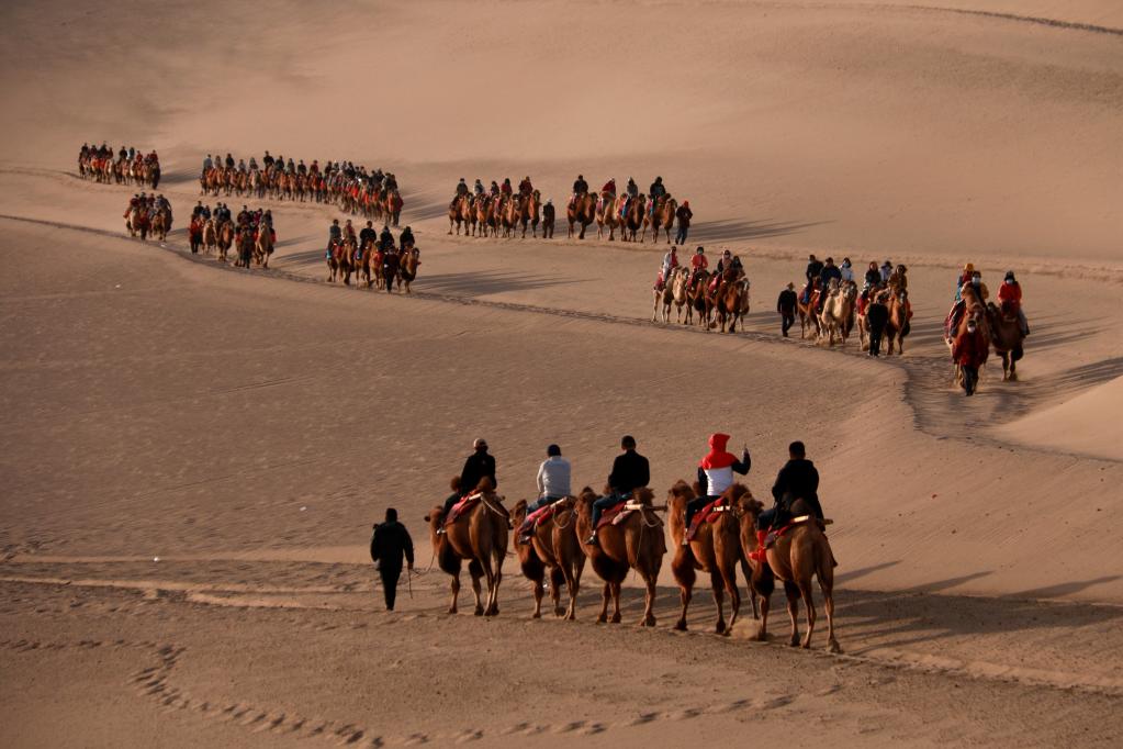 Turistas disfrutan de vacaciones en área escénica en Dunhuang, Gansu