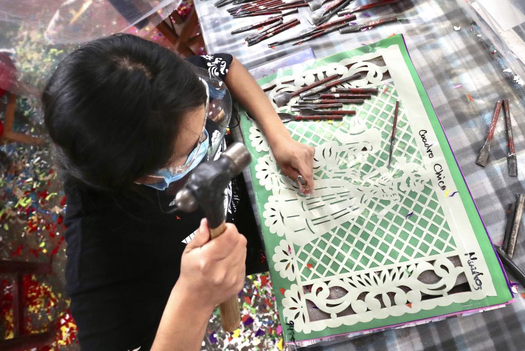Trabajadores laboran en un taller de papel picado en la Ciudad de México previo a celebración de Día de los Muertos
