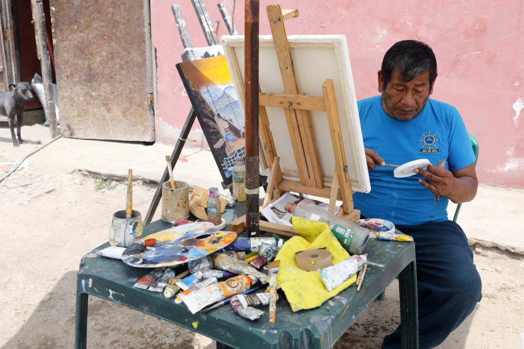 Pintor realiza cuadros de paisajes de playas cercanas y retratos de clientes en el sur de Lima, Perú