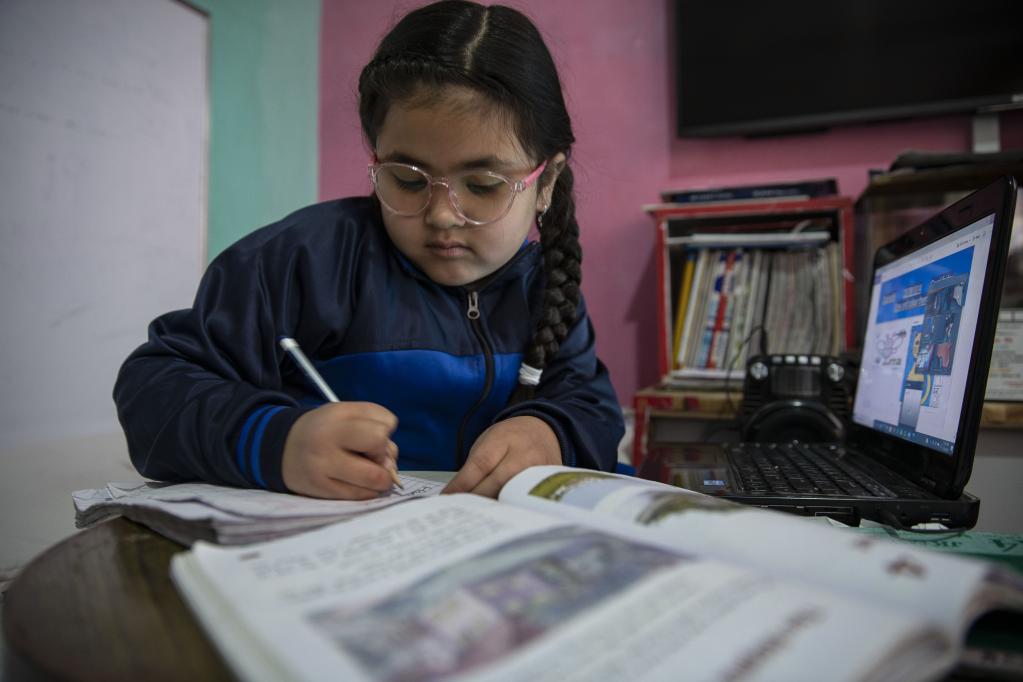 Niña toma clases en línea en su hogar en Lalitpur, Nepal