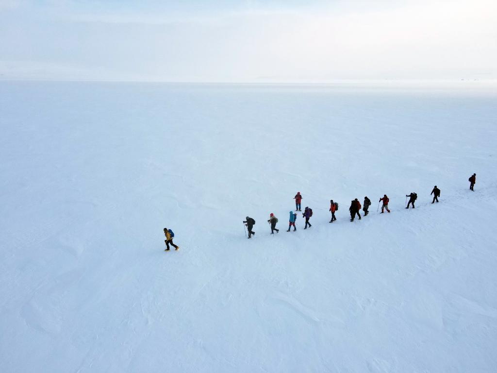 Personas realizan senderismo sobre lago Cildir congelado en Ardahan, Turquía