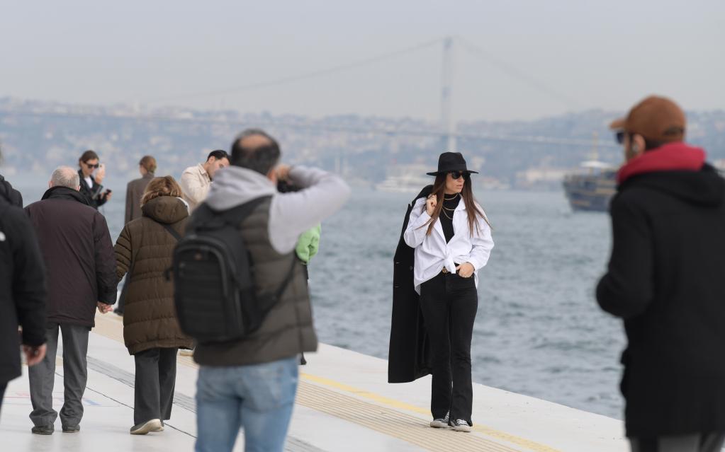 Personas pasan su fin de semana frente al Estrecho del Bósforo en Estambul, Turquía