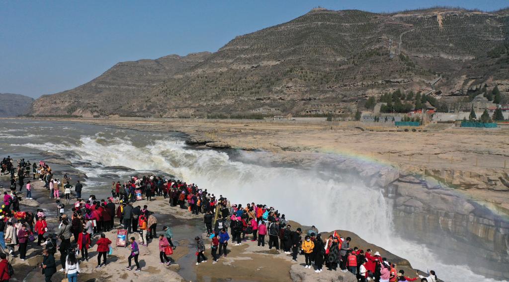 Turistas disfrutan del paisaje de la cascada Hukou en Shaanxi