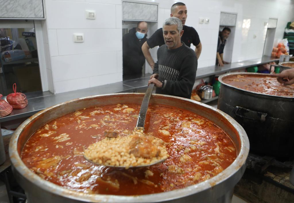 Cocineros palestinos preparan comida de caridad para distribuir comidas del Iftar durante el Ramadán