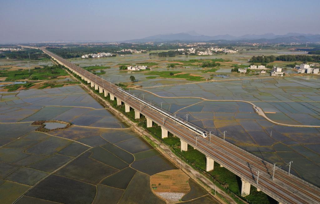 Guangxi: Vista aérea de tren de alta velocidad circulando por puente sobre los campos