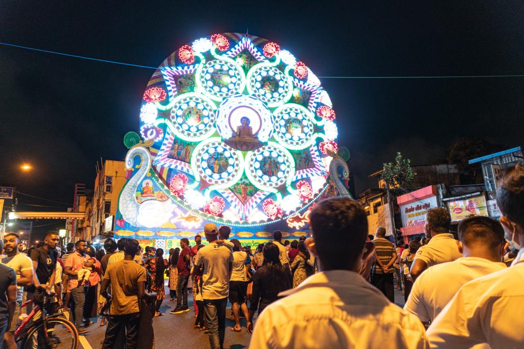 Personas observan decoraciones iluminadas para celebrar Festival de Vesak en Sri Lanka