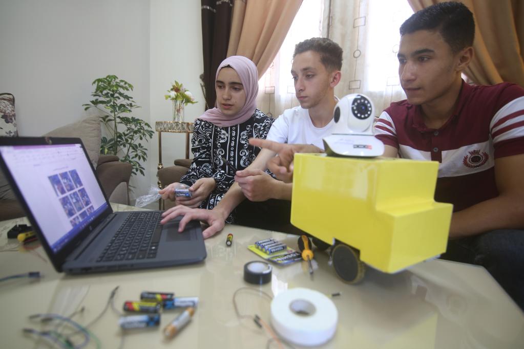 Jóvenes trabajan en un robot inteligente en el sur de la Franja de Gaza