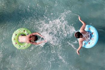 Turistas se refrescan en un parque de atracciones acuático en Suzhou