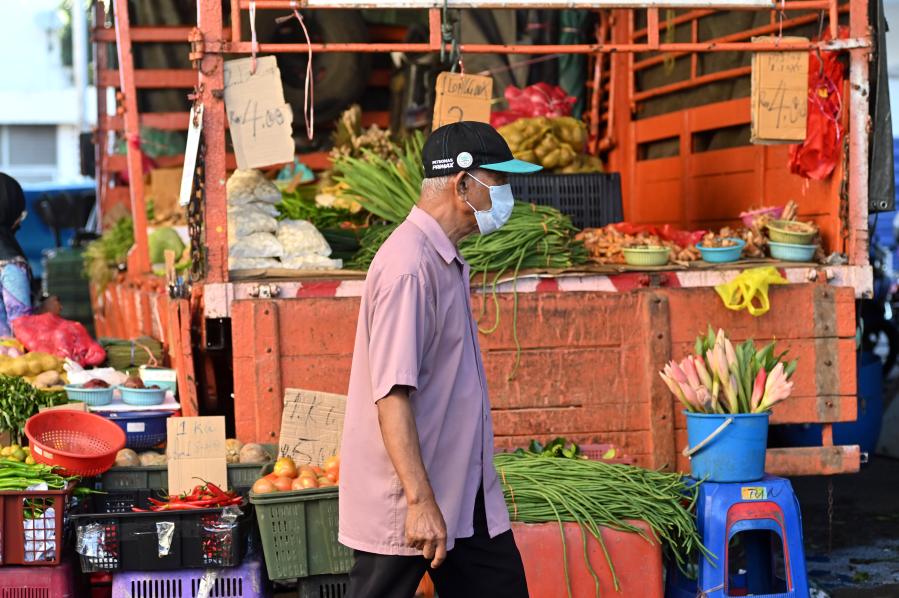 Personas portan mascarillas en Kuala Lumpur, Malasia