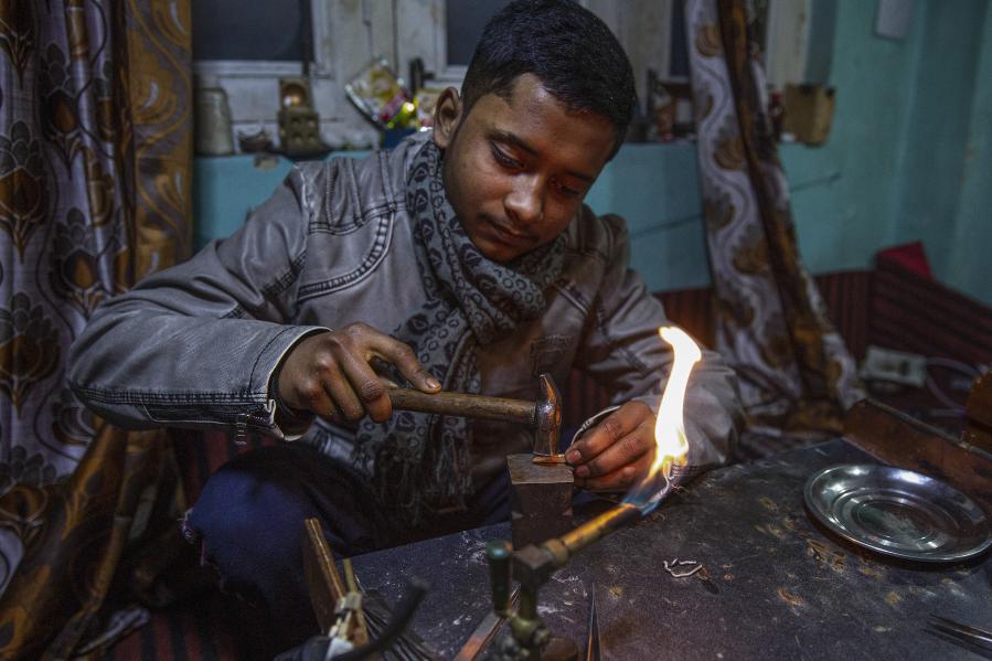 Artesano trabaja en una pieza de joyería en un taller en Srinagar
