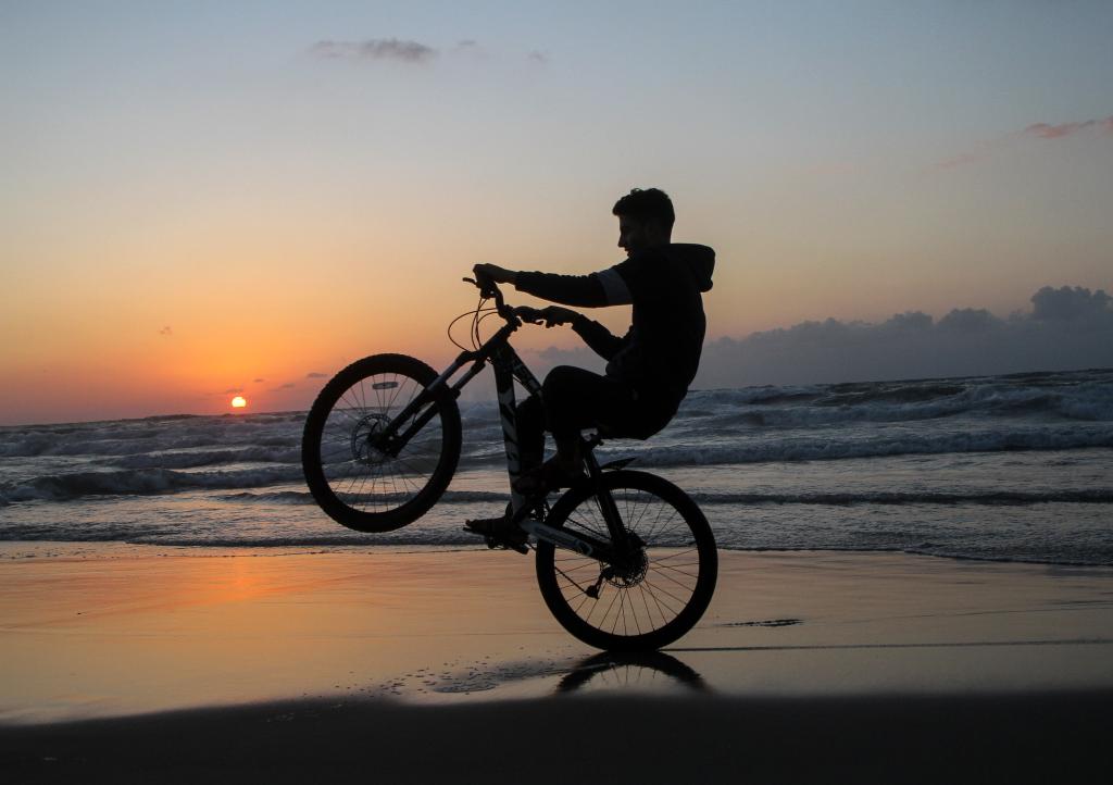 Niños palestinos disfrutan de su tiempo en playa al atardecer en la Ciudad de Gaza